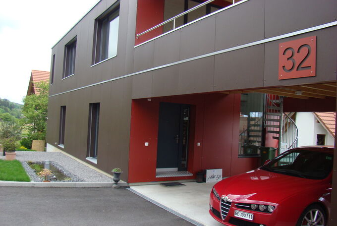 Ansicht Haus von Eingangsseite her, schön zu sehen der gelungene Kontrast der dunkelbraunen und roten Fassadenplatte