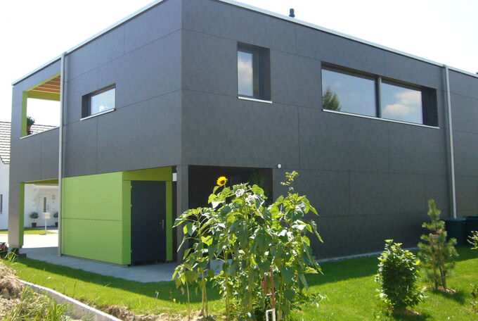 Hausansicht bei Eingang, integriertes Reduit in grün als gelungener Kontrast zur dunkelgrauen Fassade
