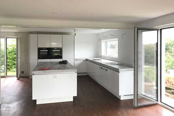 Weisse Küchenfronten mit prägnanter Betonabdeckung