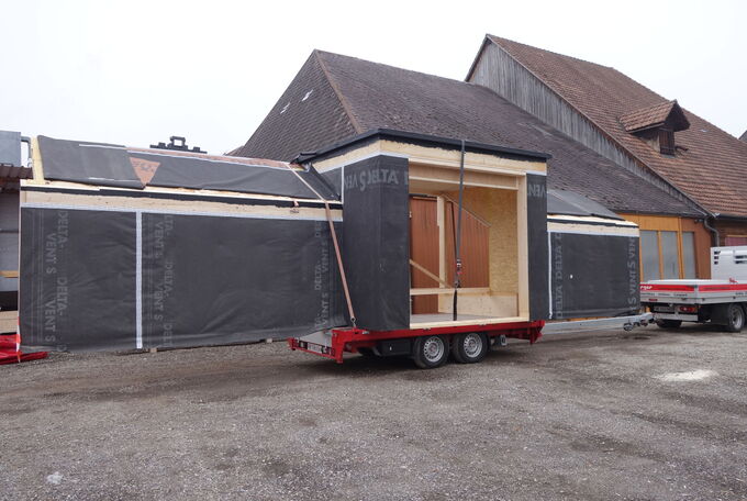 Dachelement mit integrierter Lukarne auf Anhänger, bereit um auf die Baustelle gefahren zu werden