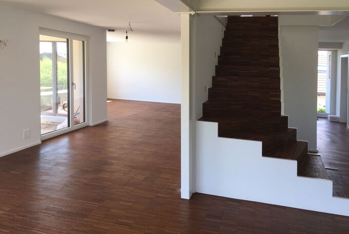 Dunkler Stabparkett als schöner Kontrast zu den neuen weissen Wänden